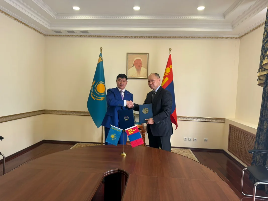 Аким Талдыкоргана Ернат Бәзіл и Посол Монголии Гунаажавын Батжаргал пожимают руки после подписания меморандума о сотрудничестве.