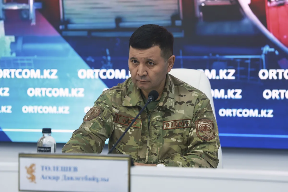 Пожарный МЧС тушит возгорание сухой травы, предупреждая распространение огня в Жетісу.