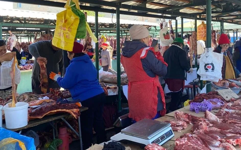 Сотрудник акимата проверяет цены на мясном прилавке рынка в Талдыкоргане.
