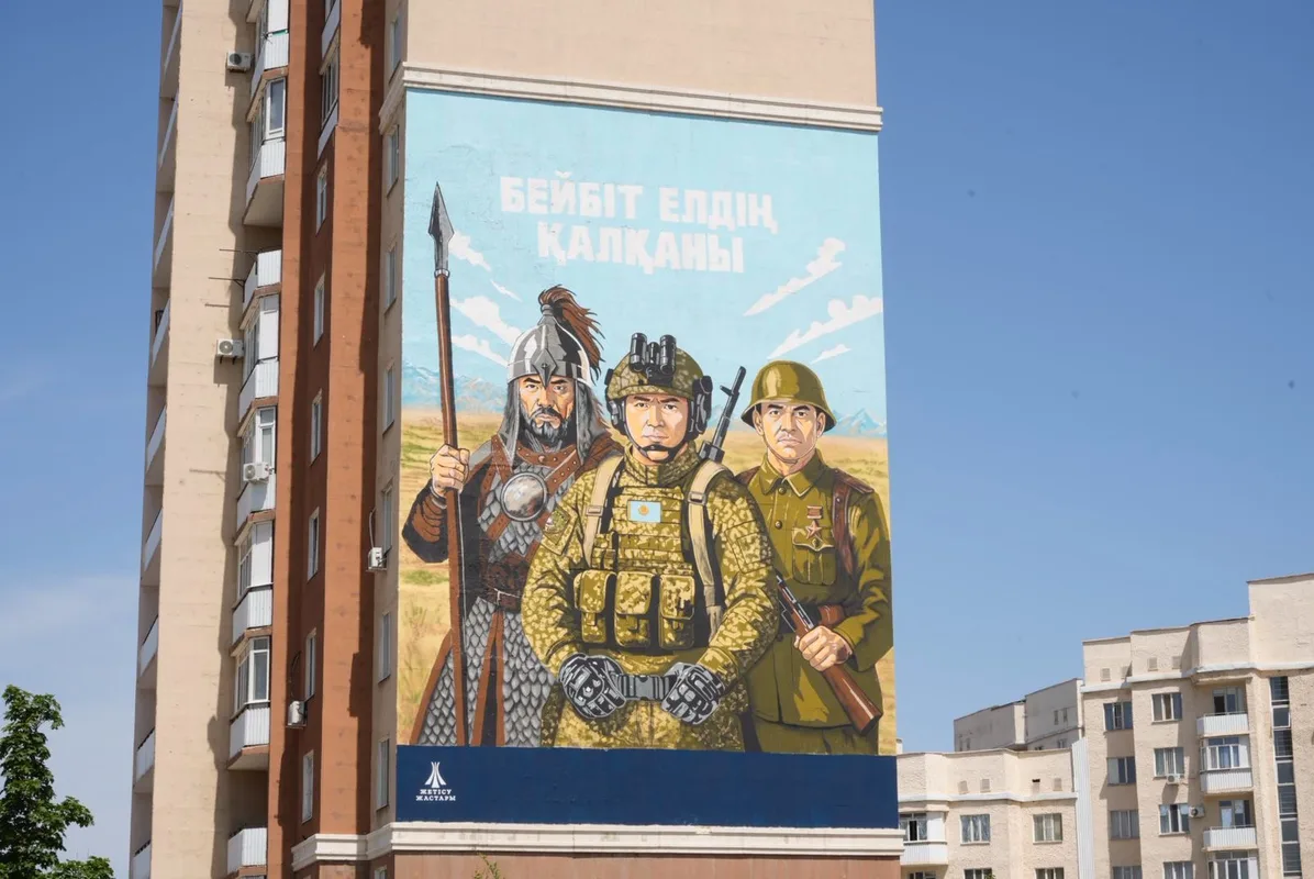 Настенный мурал «Бейбіт елдің қалқаны» с изображением трёх воинов на здании в Талдыкоргане