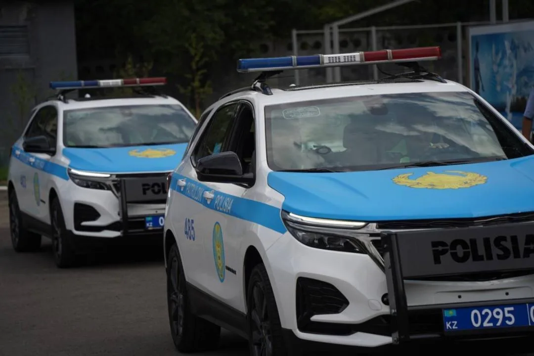 Полицейские Алматы останавливают колонну автомобилей, участвующих в незаконном автокортеже выпускников на городской улице.