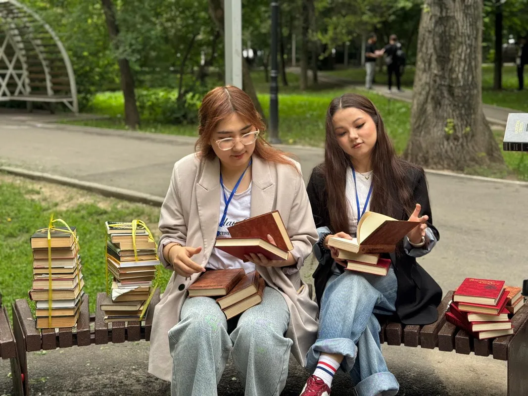 Книги на полках для буккроссинга в городском парке Алматы под открытым небом, 2026 год.