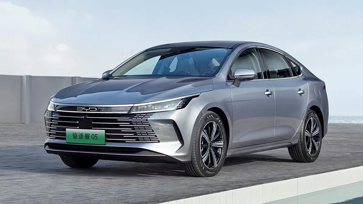 Гибридный автомобиль BYD в городе, на фоне гор Жетісу