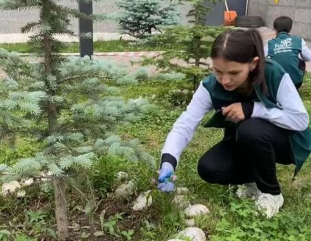 Подростки в зелёных жилетах отряда «Жасыл ел» убирают мусор на улице Текели.