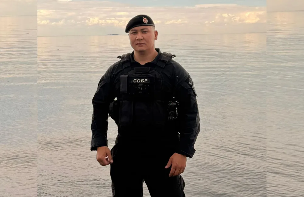 Полицейский спецназа спасает людей в воде во время шторма на озере Алаколь