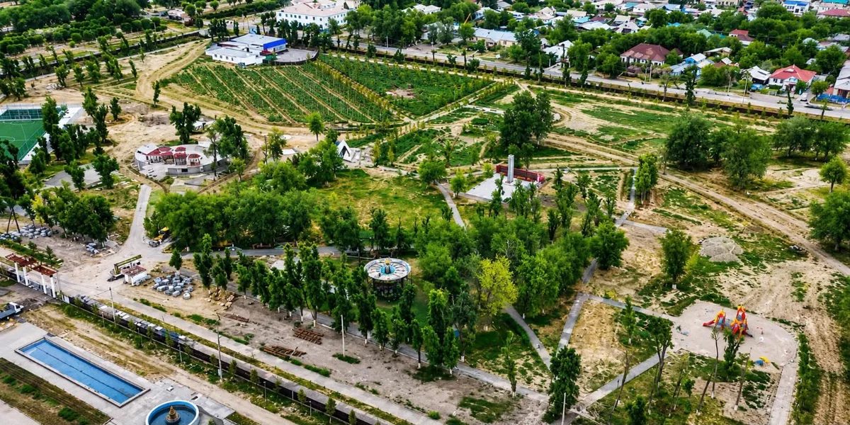 Рабочие устанавливают систему автоматического капельного орошения на зелёной аллее в Уштобе.