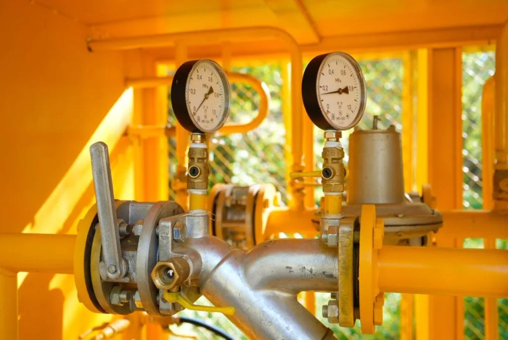 Трубы газопровода на фоне степного пейзажа, символизирующие развитие газоснабжения в Жетісу.