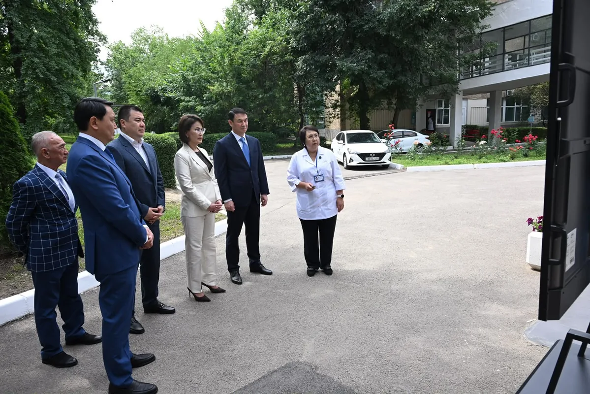 Министр здравоохранения и аким Алматы осматривают новое автоматизированное лабораторное оборудование в больнице.