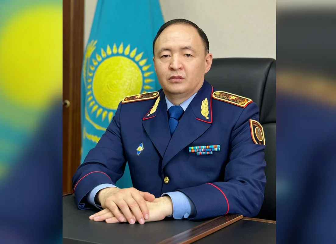 Сотрудник полиции Жетісу на фоне мониторов Центра оперативного управления с изображением камер видеонаблюдения