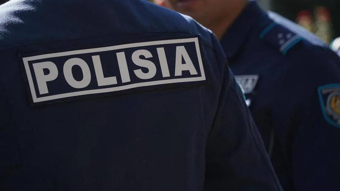 Полицейские и волонтёры закрашивают надписи с наркорекламой на стене здания в Текели