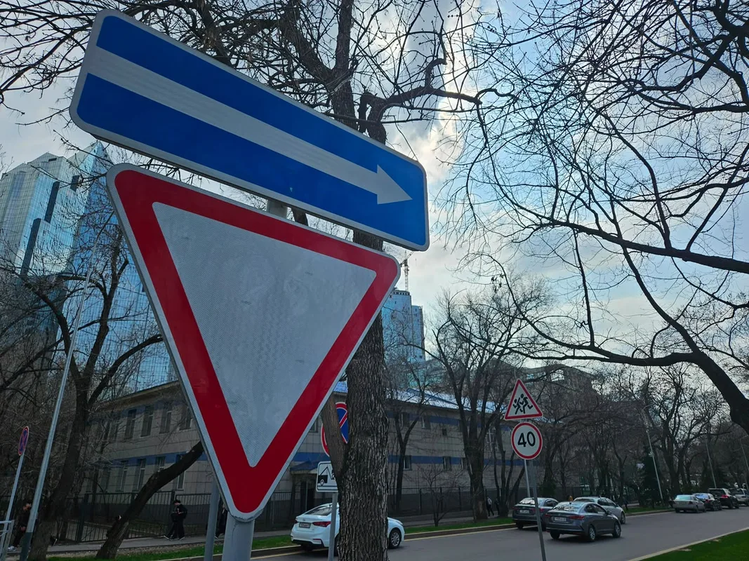 Автомобили движутся по улице Алматы, где вводится новая схема одностороннего движения для улучшения трафика.