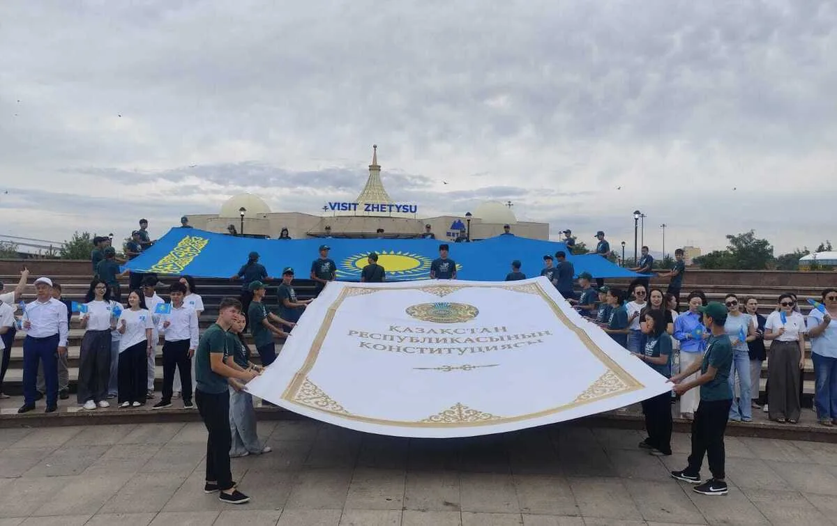 Молодые активисты с флагами Казахстана на флешмобе в Талдыкоргане, посвященном Конституции