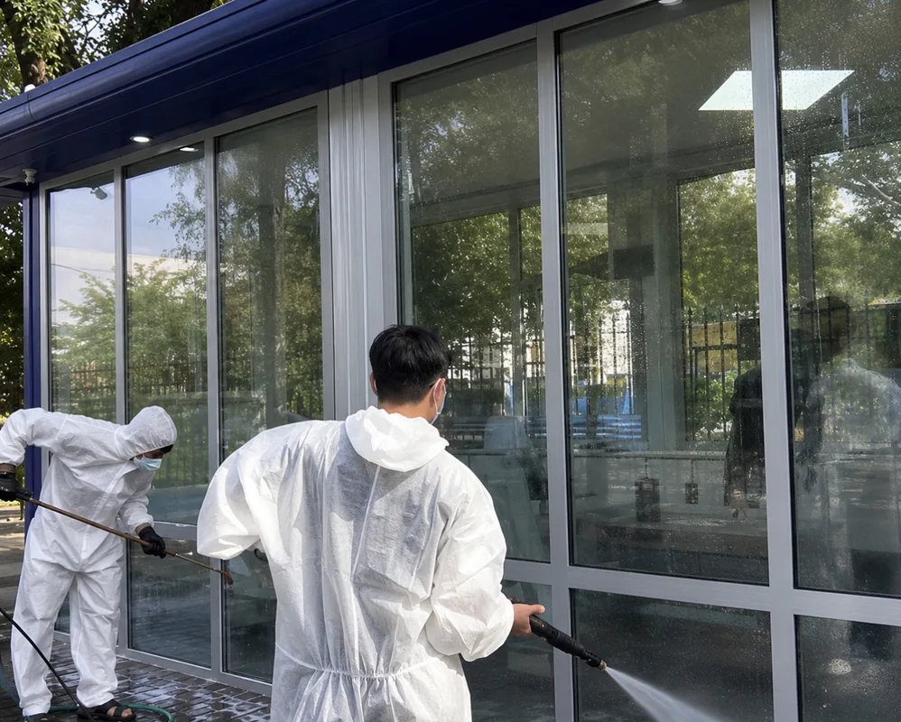 Рабочие красят остановку общественного транспорта в Талдыкоргане на фоне городской улицы.