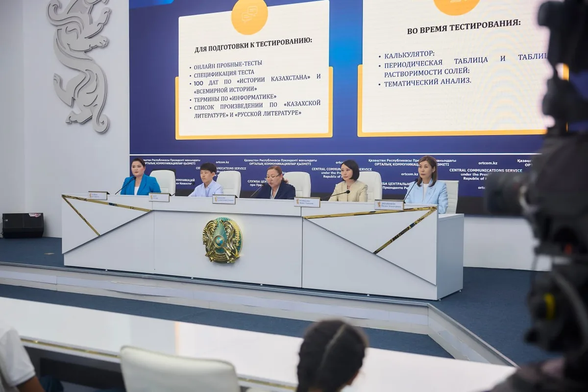 Молодой абитуриент сосредоточенно решает задания ЕНТ за компьютером в тестовом центре.