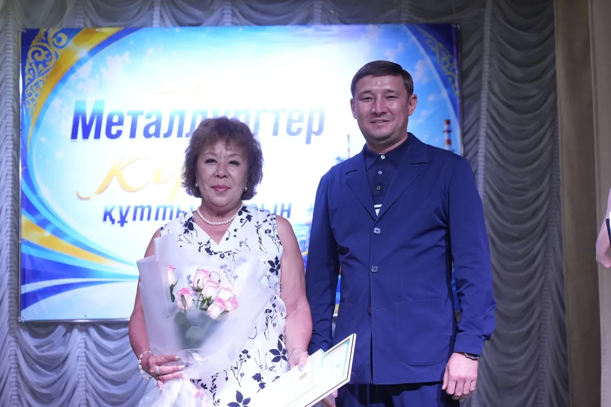 Заместитель акима Текели вручает почетные грамоты ветеранам металлургической отрасли на торжественном мероприятии.