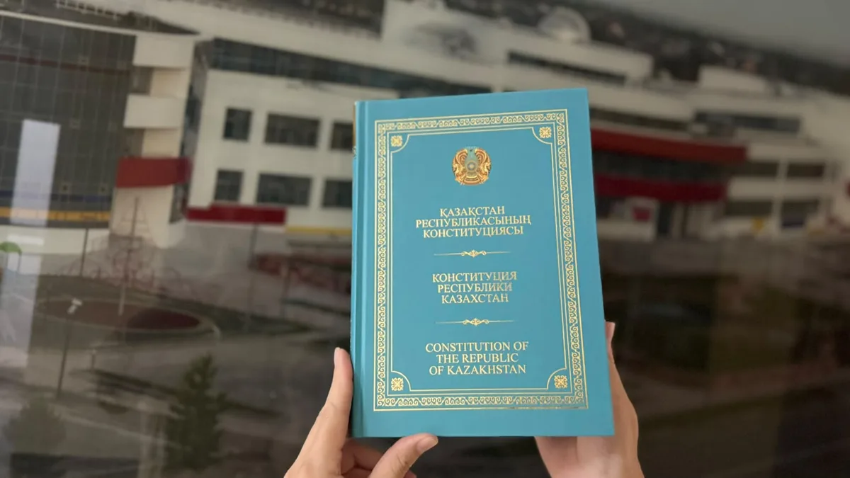 Мужчина в наручниках и полицейская машина, символизирующие новые гарантии прав задержанных в Казахстане.