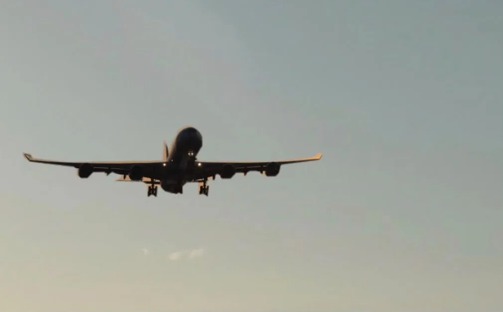 Самолет авиакомпании FlyArystan приземляется в международном аэропорту Батуми, Грузия, на фоне гор и моря.