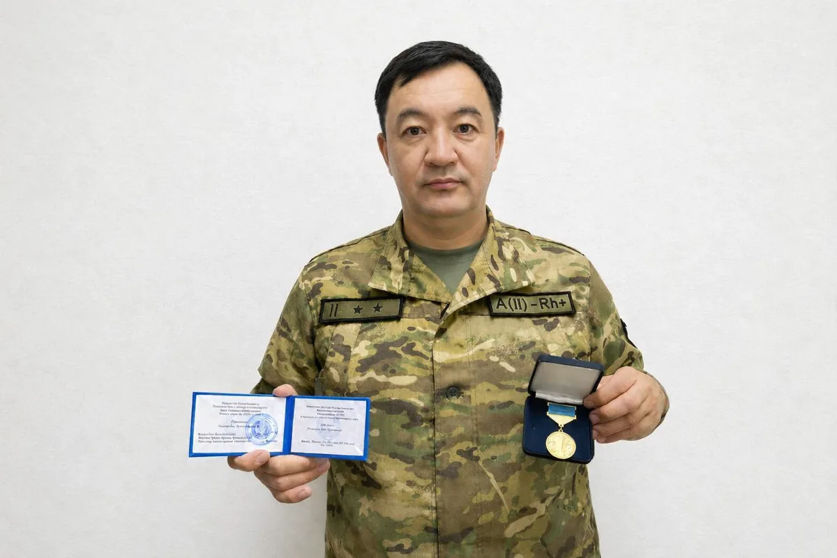 Военный журналист Манарбек Карекенов, подполковник КНБ Жетісу, демонстрирует нагрудный знак «Ақпарат саласының үздігі»