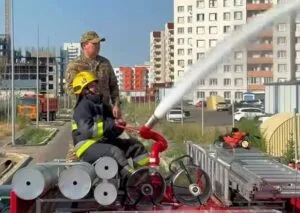 Дети Талдыкоргана играют под струями воды, устроенными пожарными в жару.