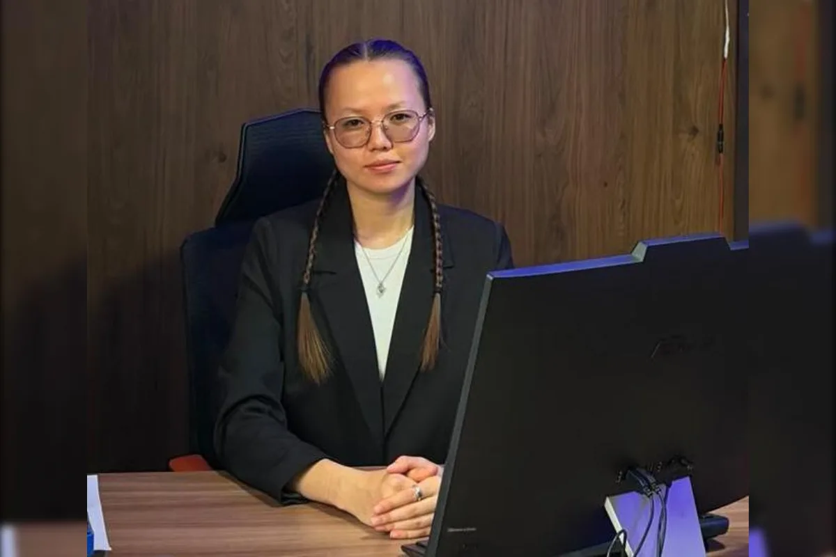 Молодые люди изучают Конституцию Республики Казахстан, сидя за столом