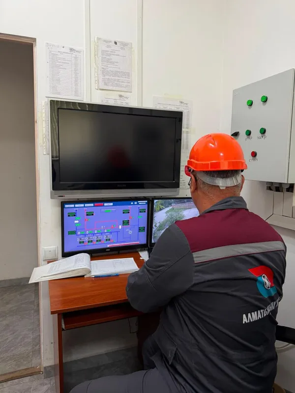 Рабочие проводят проверку тепловых труб на улице в Алматы перед отопительным сезоном.