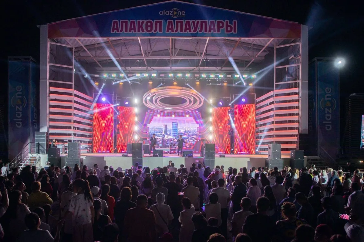 Сцена культурно-туристского фестиваля «Алакөл алаулары – 2026» с тысячами зрителей на побережье озера Алаколь.