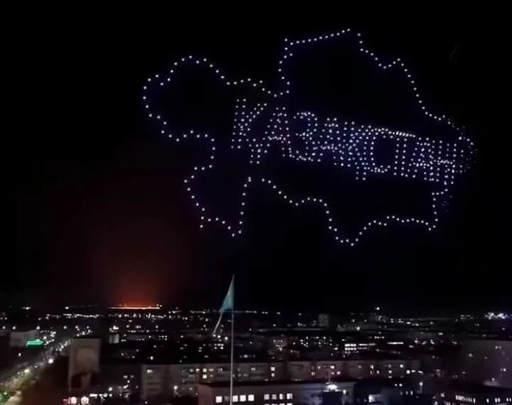 Казахстанские певцы Беркут и Аиша выступают на сцене перед толпой зрителей с дрон-шоу над городом Талдыкорган.