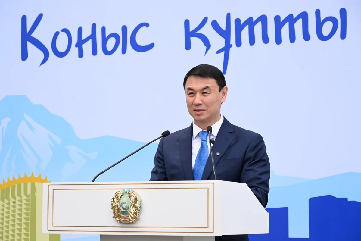 Аким Алматы Дархан Сатыбалды вручает ключи от новой квартиры жителям, стоящим в очереди на жилье.