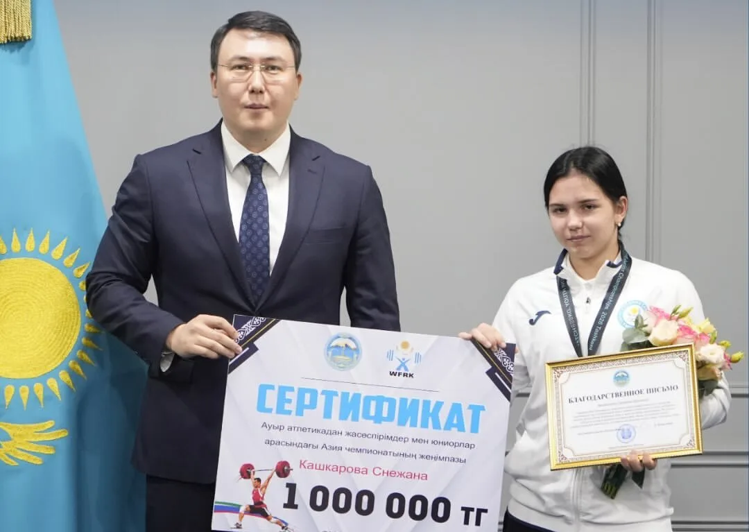 Снежана Кашкарова с медалями и благодарственными письмами в окружении других тяжелоатлетов и официальных лиц в области Жетісу.
