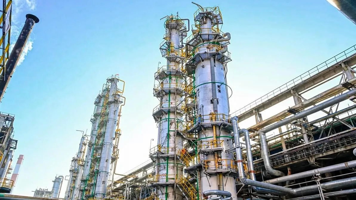 Панорама нефтеперерабатывающего завода с множеством промышленных сооружений, труб и резервуаров