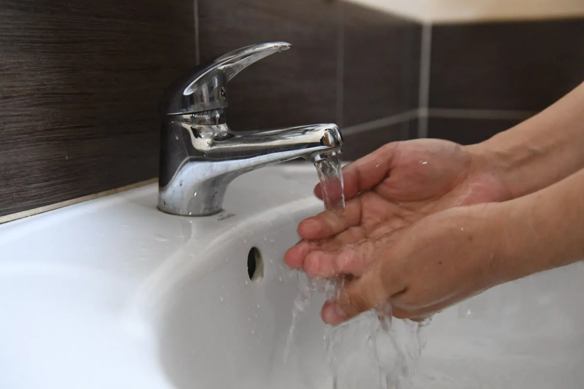 Рабочие проводят техническое обслуживание сетей водоснабжения в городском районе, готовясь к плановому отключению воды.