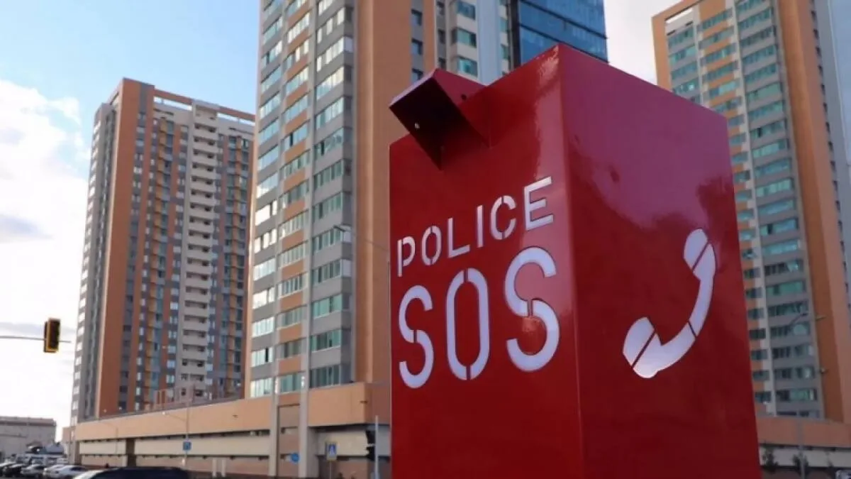 Житель Астаны нажимает на SOS-кнопку экстренного вызова полиции, установленную на городском столбе.