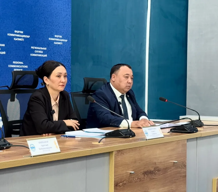 Медсестра разговаривает с пациентом в поликлинике области Жетісу, демонстрируя доступность медицинских услуг.