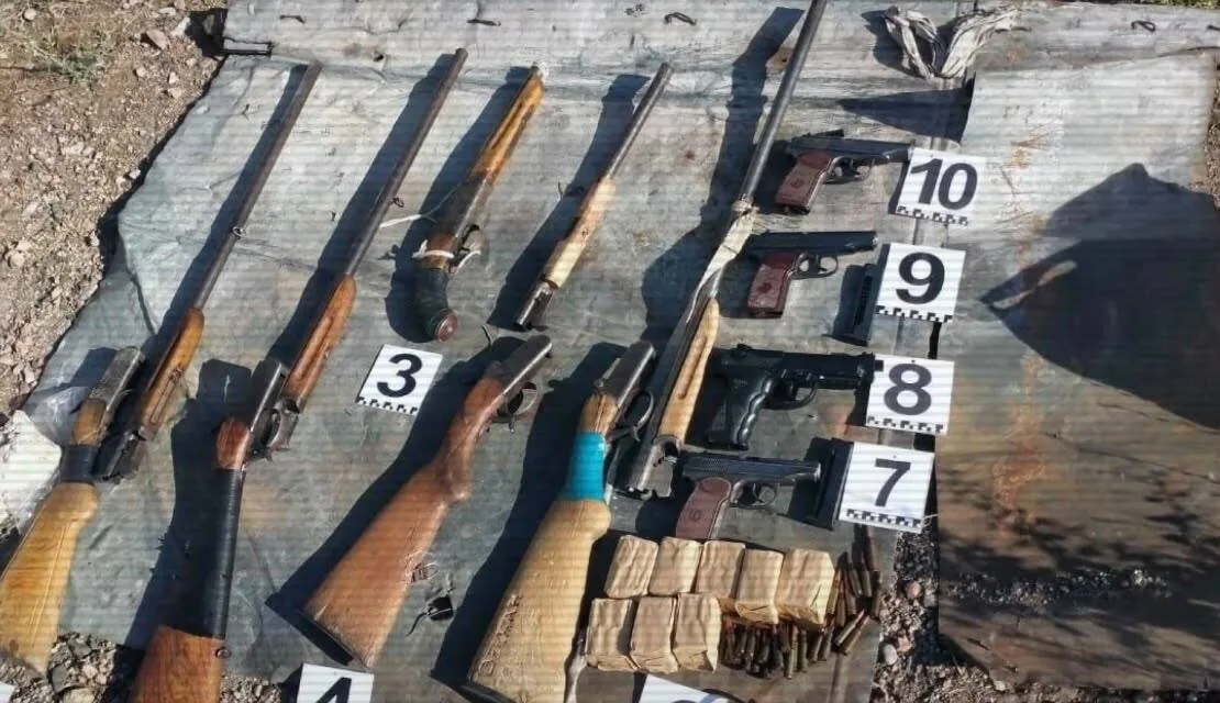 Полицейские изымают незаконно хранившееся оружие, включающее автоматы и пистолеты, в ходе операции по борьбе с преступностью.