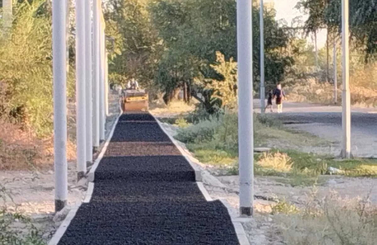 Рабочие укладывают асфальт на новой пешеходной зоне в микрорайоне Головацкого в Жаркенте