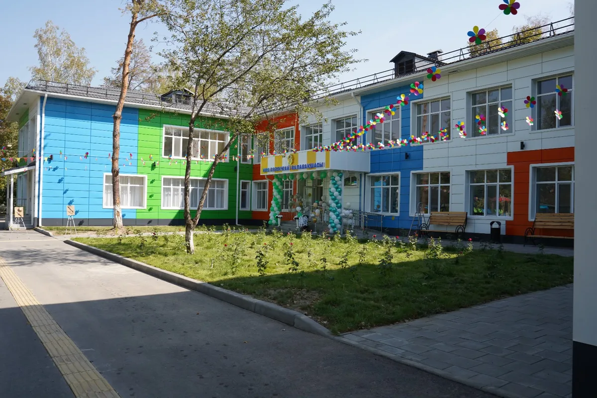 Отремонтированное здание детского сада в Алматы, возможно, с яркой детской площадкой или фасадом