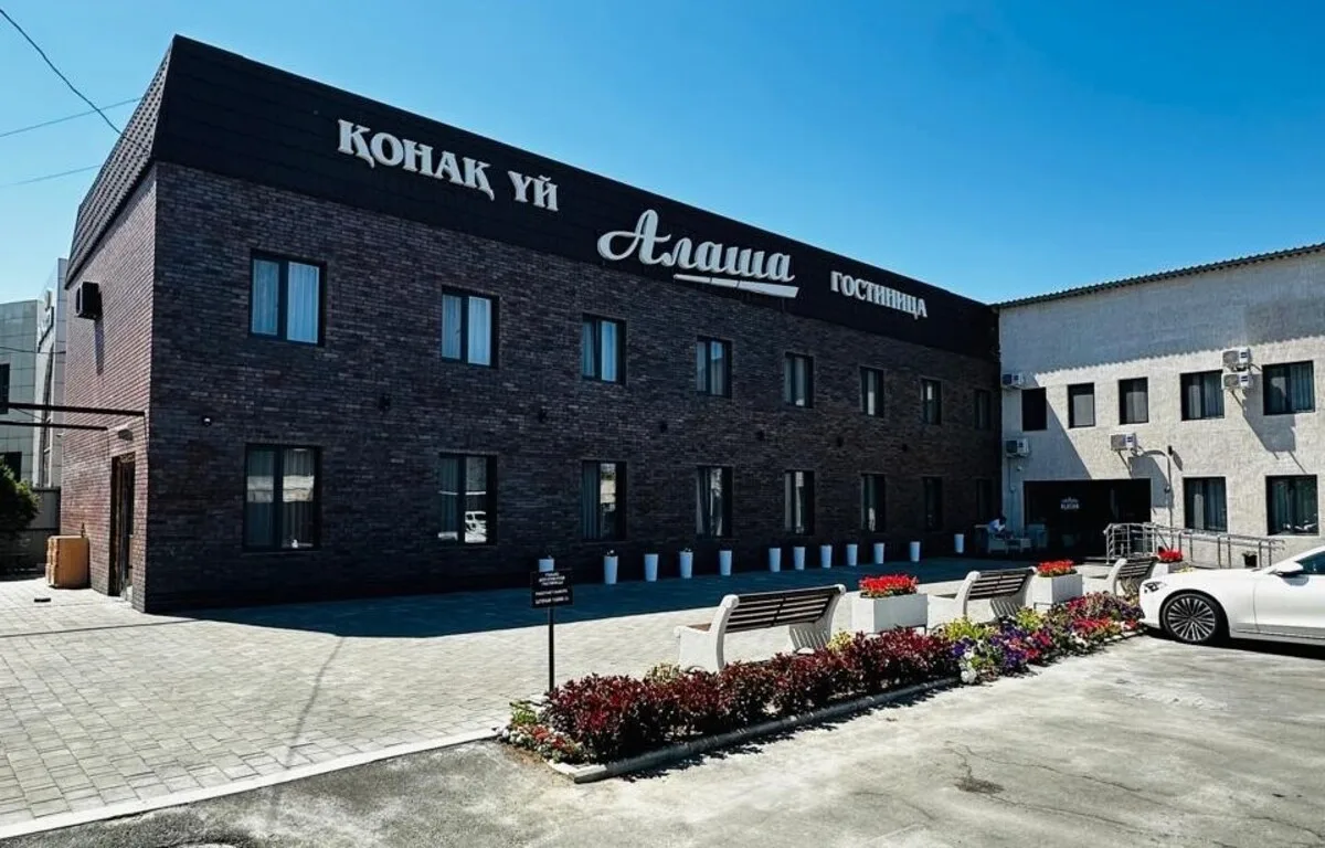 Владелица гостиницы Алаша Гульназ Кененбаева на фоне отеля в Талдыкоргане, область Жетісу.