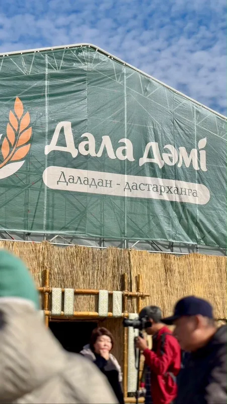 Покупатели выбирают свежие овощи и фрукты на сельскохозяйственной ярмарке в Казахстане.