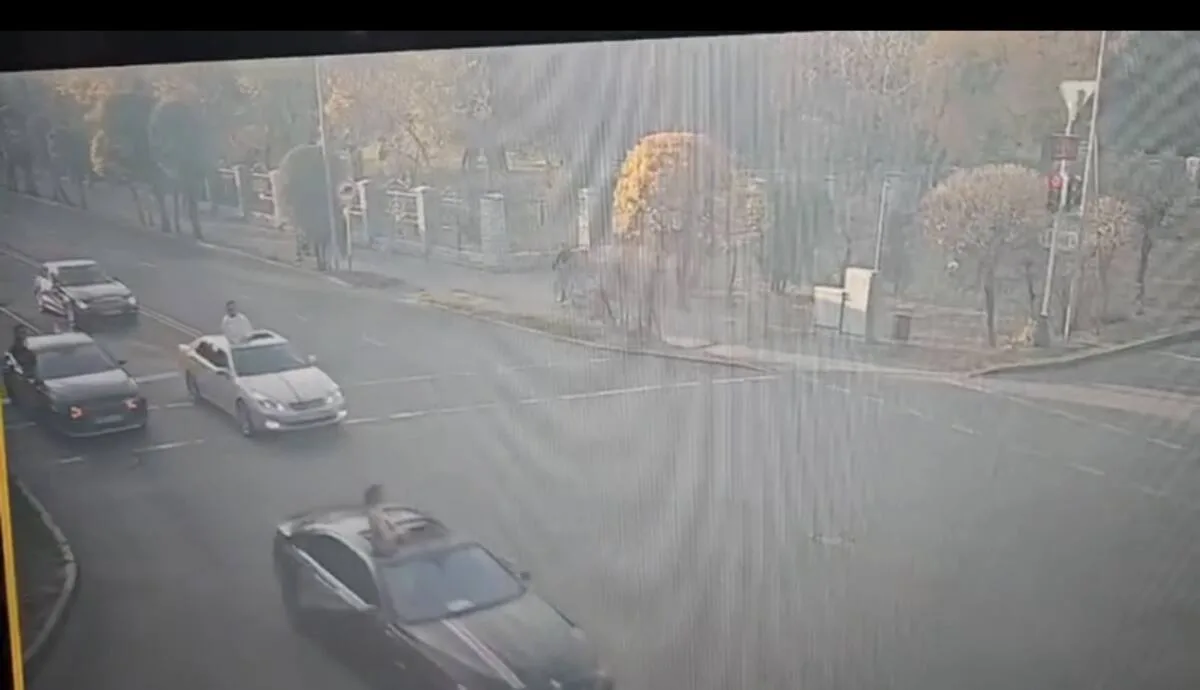 Молодые люди высовываются из люка движущегося автомобиля в Талдыкоргане