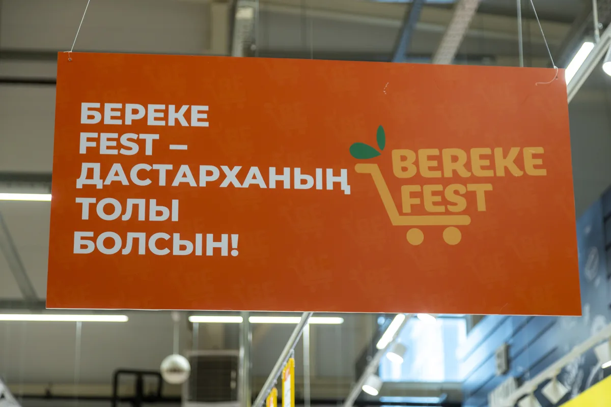 Покупатели в торговом центре на фоне рекламных вывесок о скидках к Дню Республики