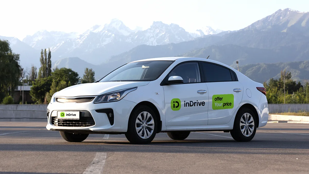 Логотип сервиса inDrive на экране смартфона, символизирующий предупреждение Агентства по защите и развитию конкуренции Республики Казахстан о росте цен на такси.