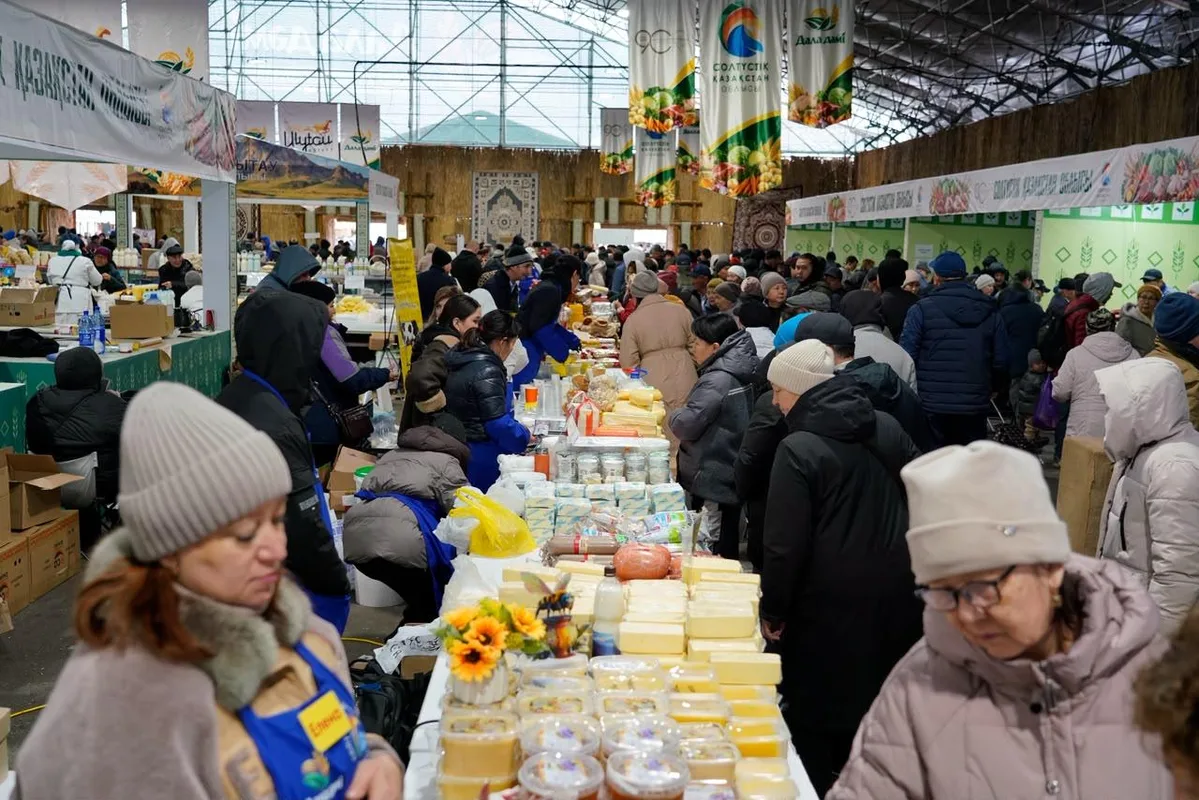 Покупатели выбирают свежие овощи и фрукты на сельскохозяйственной ярмарке в Астане.