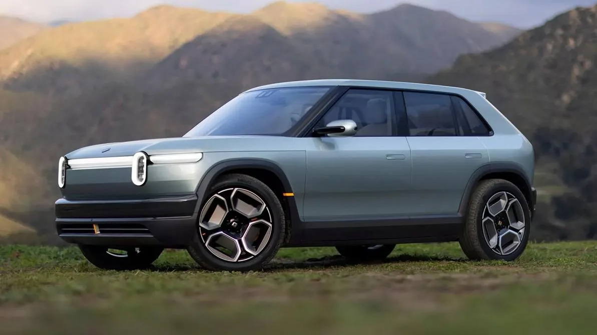 Красный электрокроссовер Rivian R3, припаркованный на горной дороге, демонстрирует стильный дизайн.