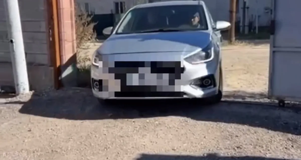 Сотрудник полиции проверяет документы водителя у автомобиля Hyundai Accent на трассе в Жетісу