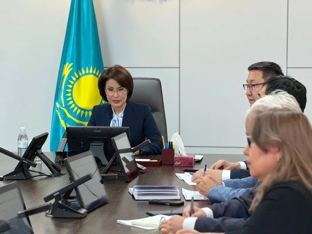 Врачи консультируют пациентов в современной поликлинике, символизируя улучшение системы оценки и качества медицинских услуг в Казахстане.